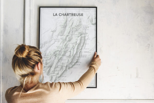 Affiche carte de la chartreuse dans un cade noir tenu par une femme